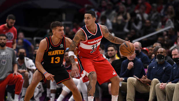 Wizards forward Kyle Kuzma dribbles into Hawks guard Bogdan Bogdanovic.